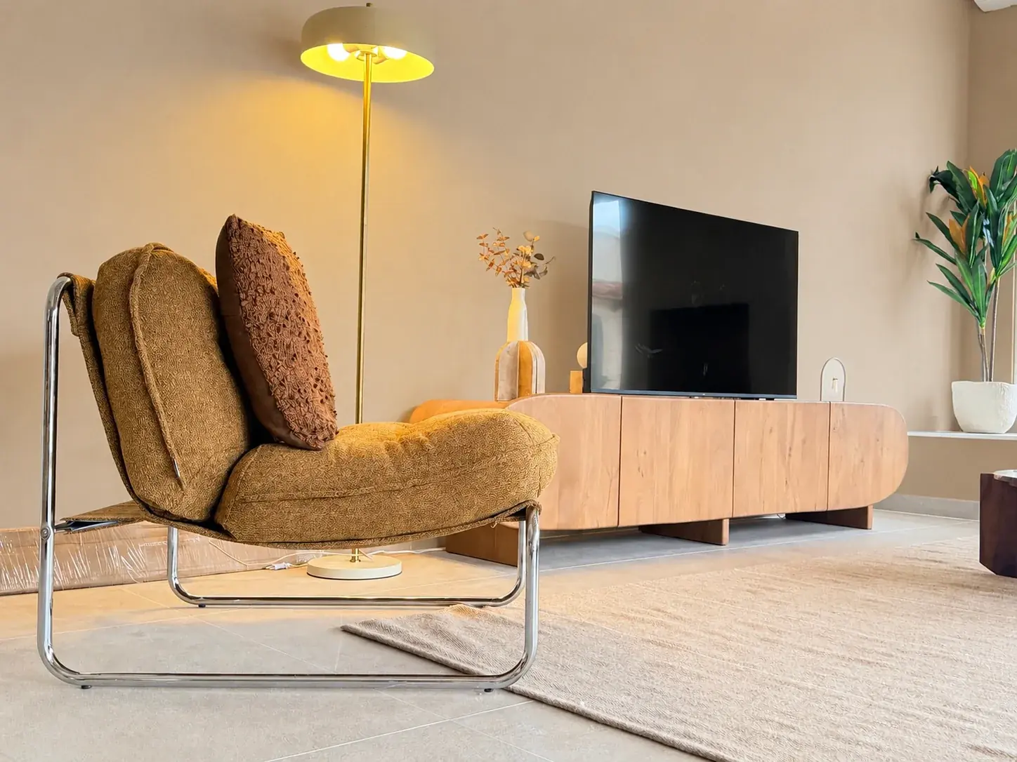 Fauteuil met kussens en staande lamp in de woonkamer van Villa SoCa
